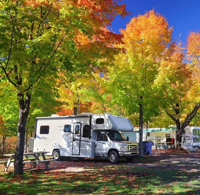 A White RV is Parked in a Campground