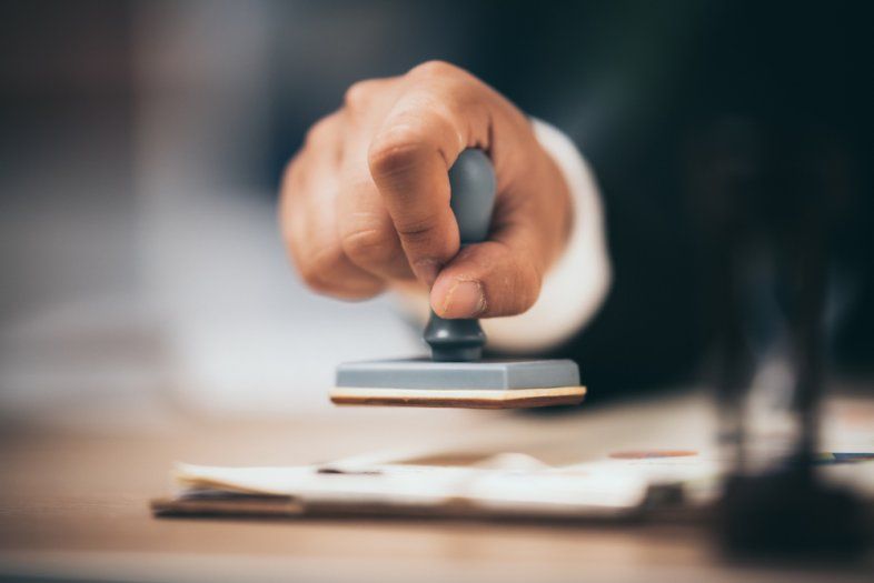 A person is stamping a document on a clipboard.