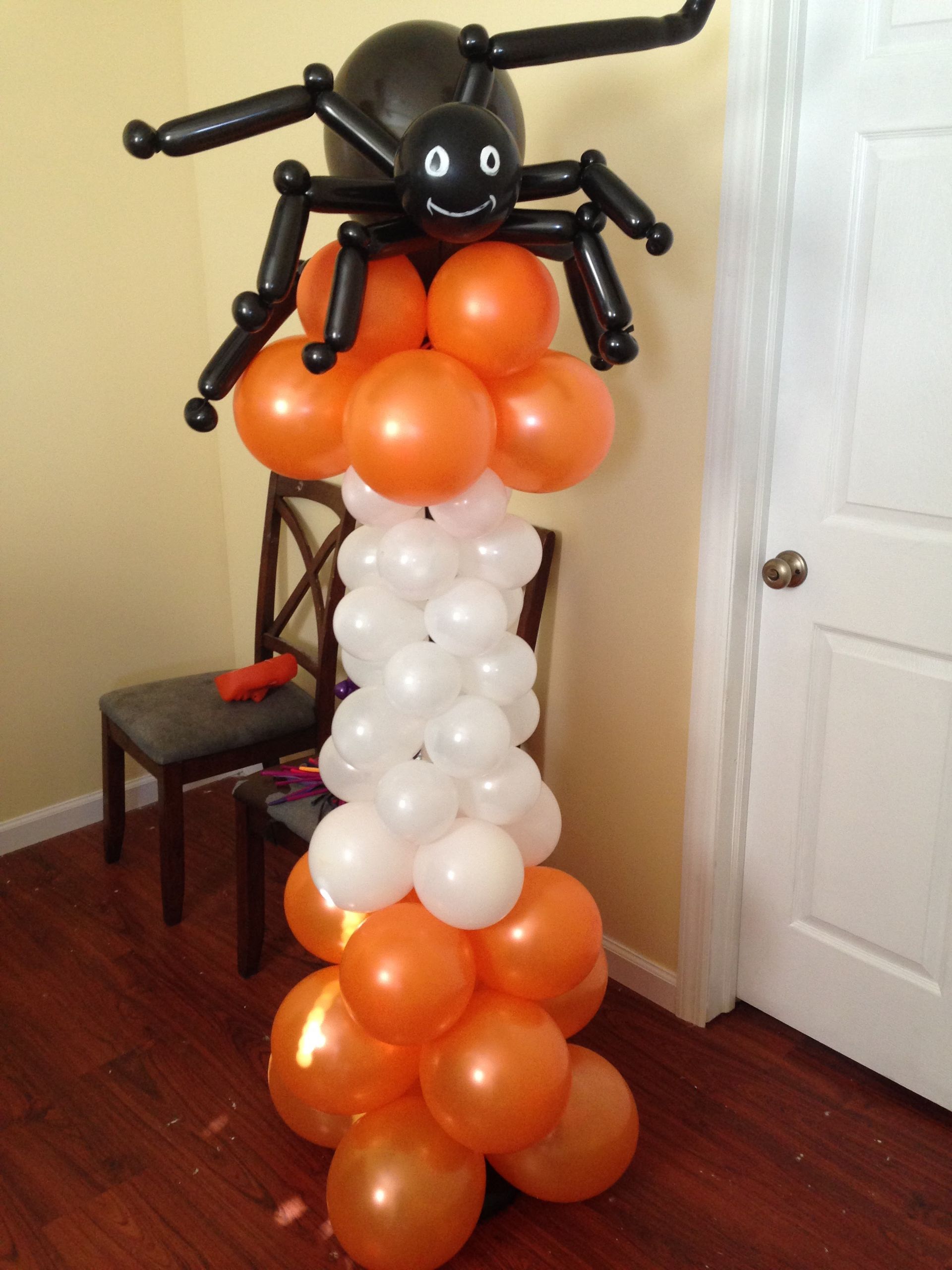 Balloon spider decoration with orange and white balloons.