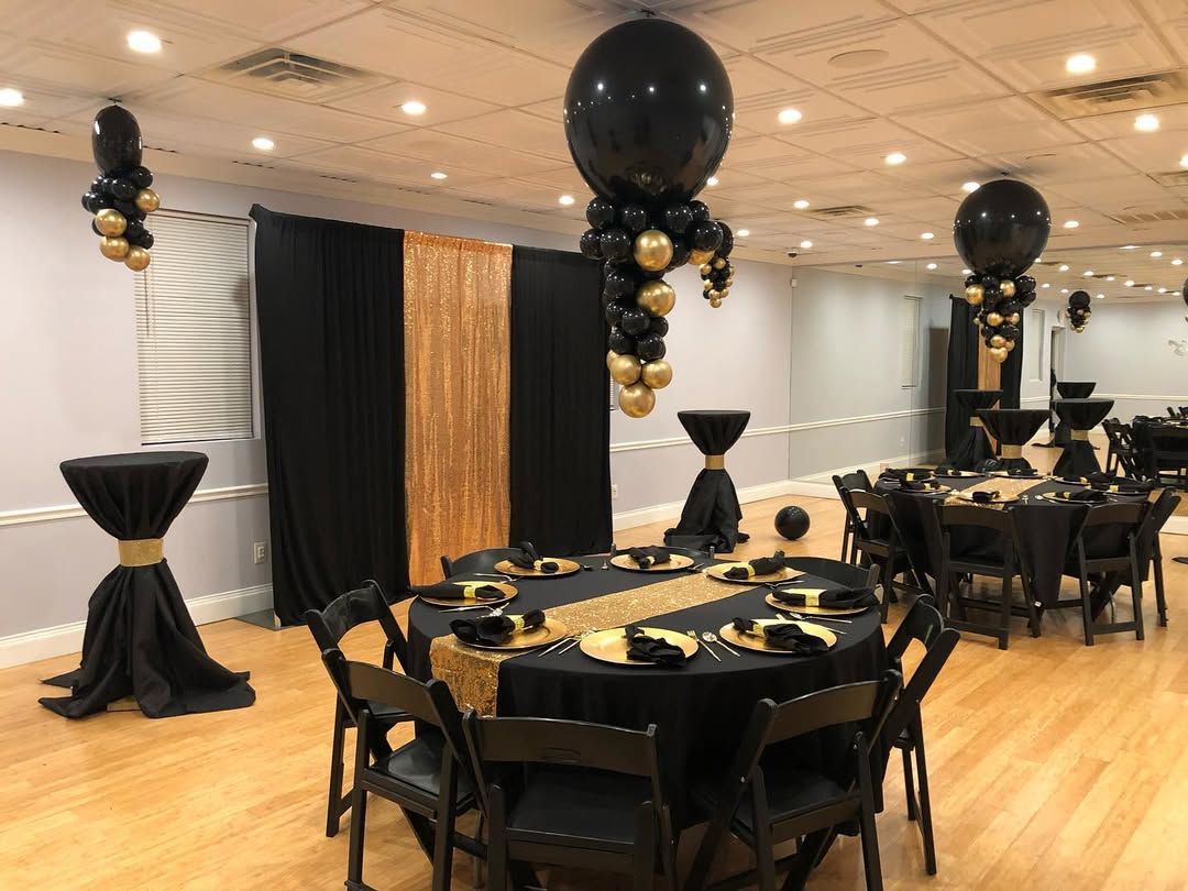 A room with tables and chairs and balloons hanging from the ceiling.