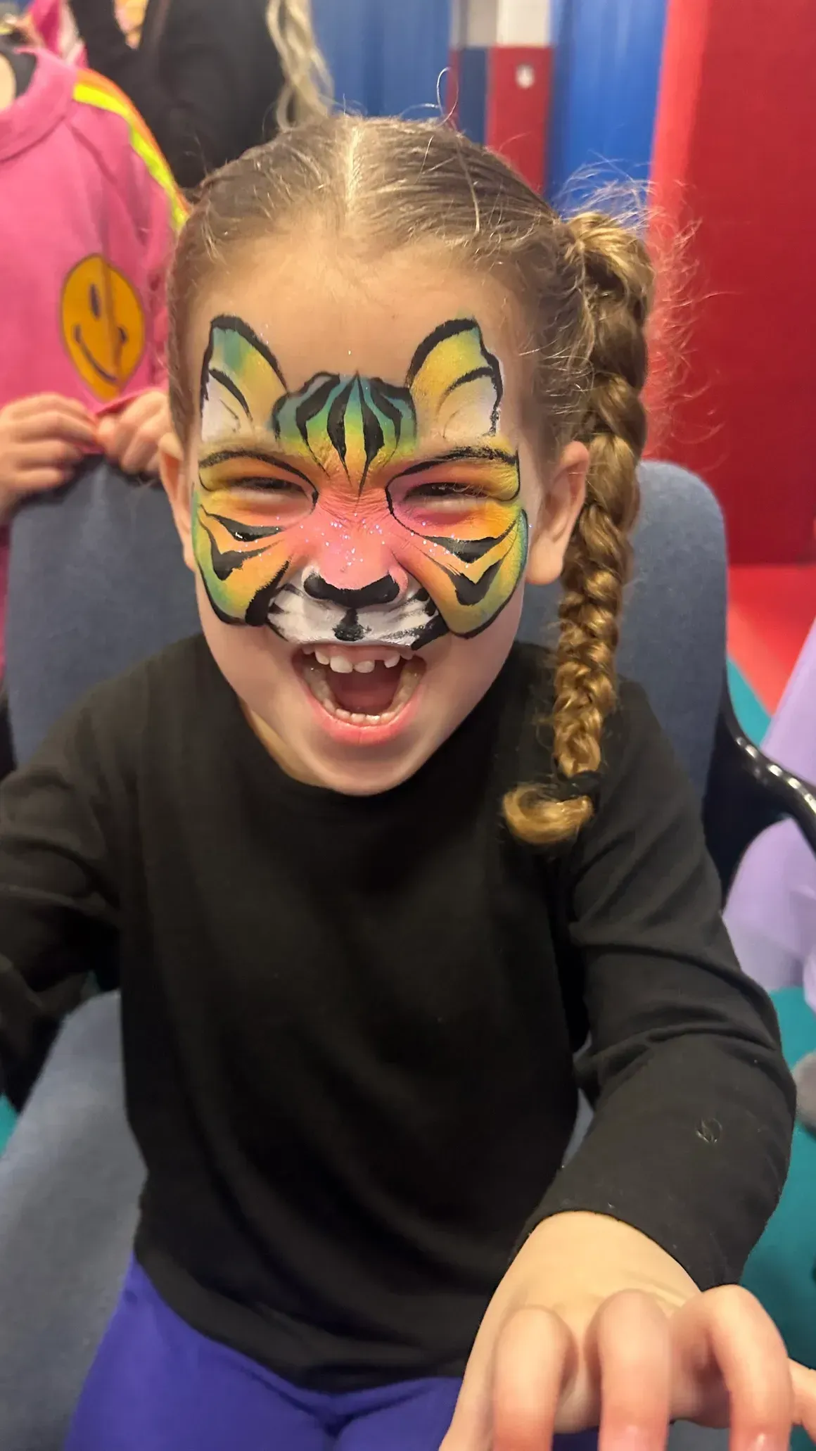 A little girl with her face painted like a tiger
