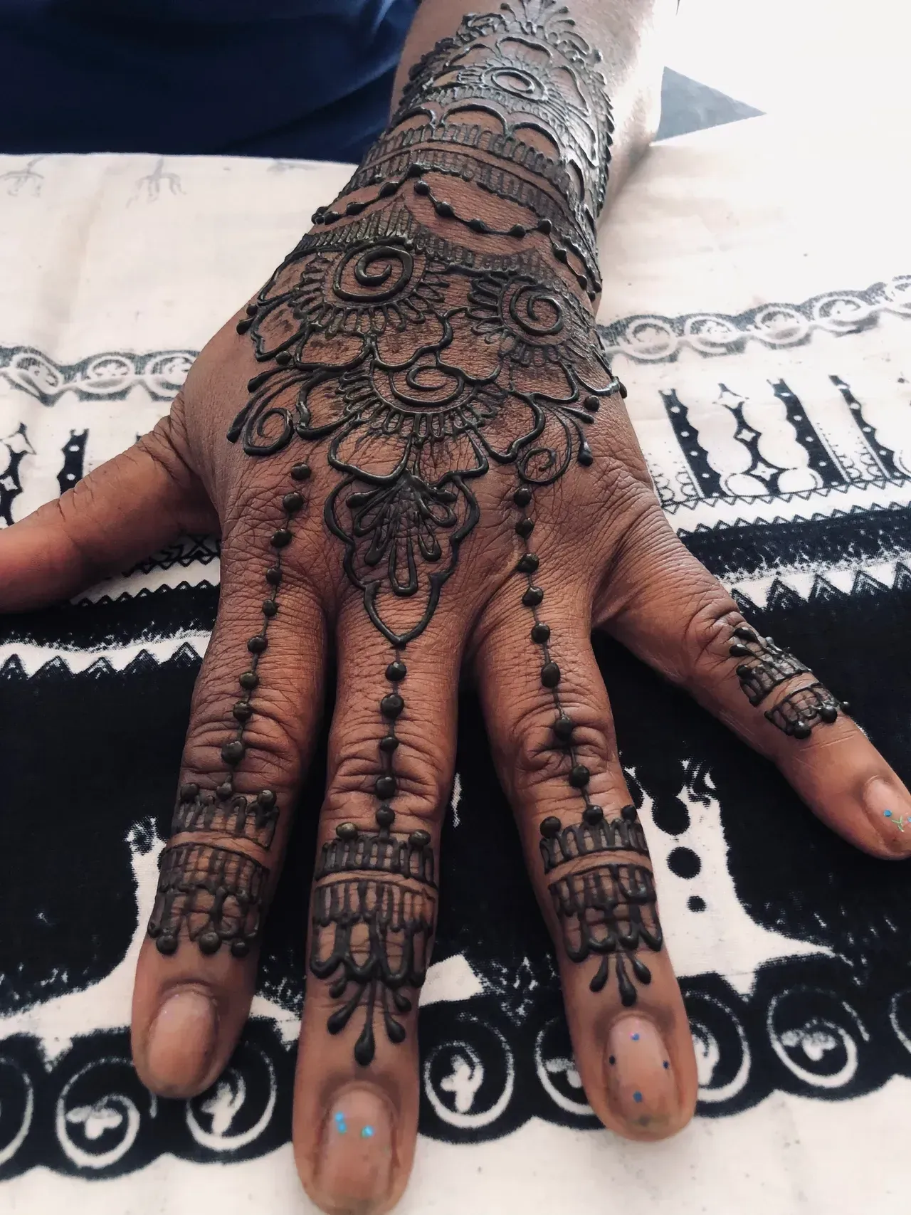 A woman 's hand with a henna design on it