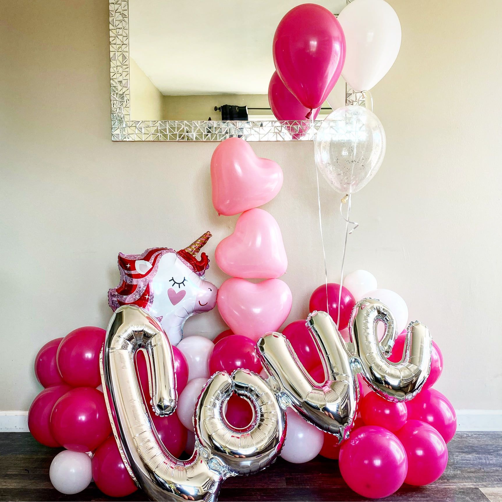 A bunch of pink and white balloons with the word love on them