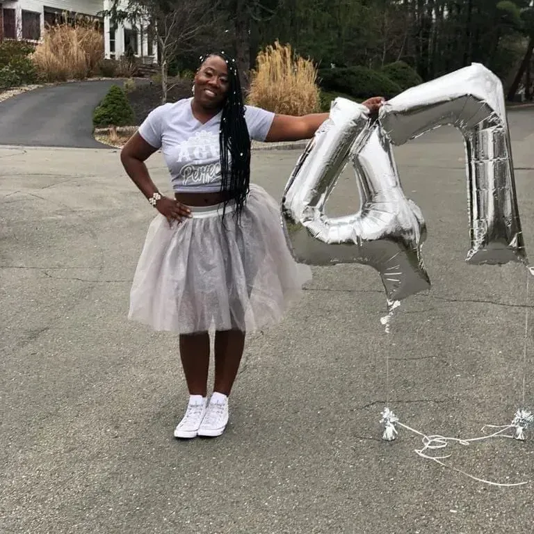 Woman in gray outfit holding