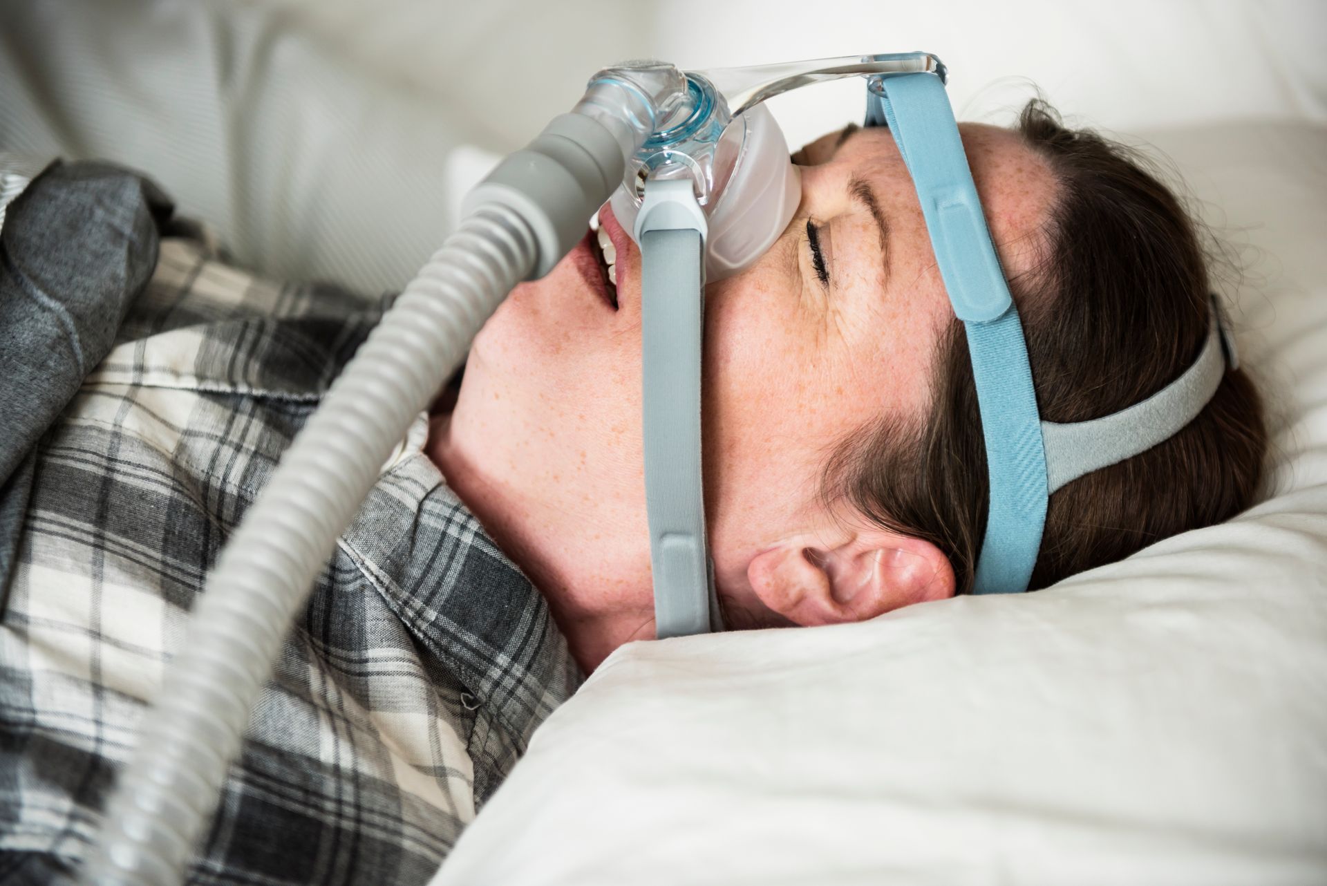 A woman is sleeping with an oxygen mask on her face.