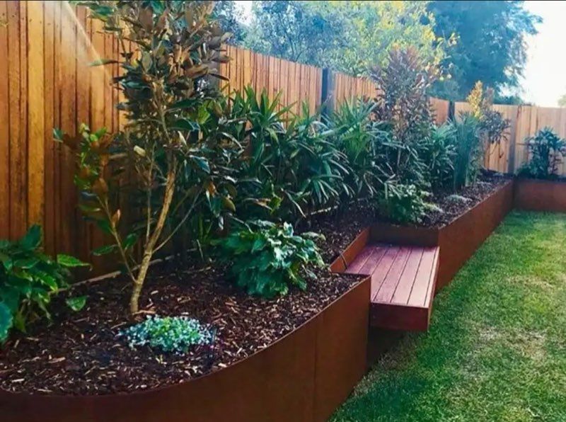 Raised garden bed with a wooden fence and landscaping.