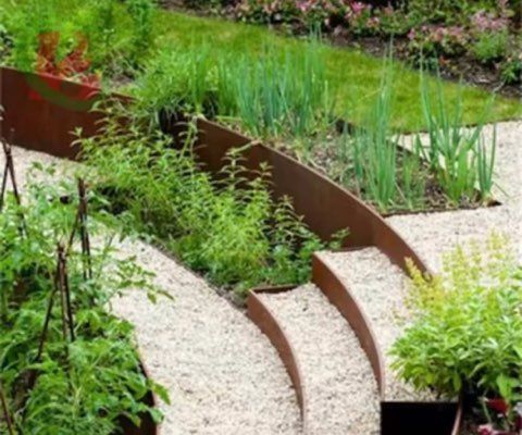 Curved metal garden beds with gravel paths; various green plants and herbs grow within.