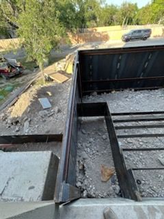 Construction site with a metal frame, gravel, and debris.