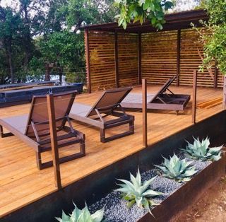 Wooden deck with lounge chairs and agave plants; a shaded relaxation area outdoors.