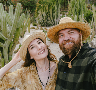 A man and a woman wearing straw hats are posing for a picture.