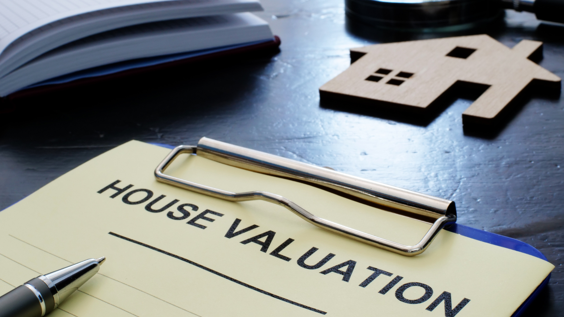 A clipboard with the word house valuation on it