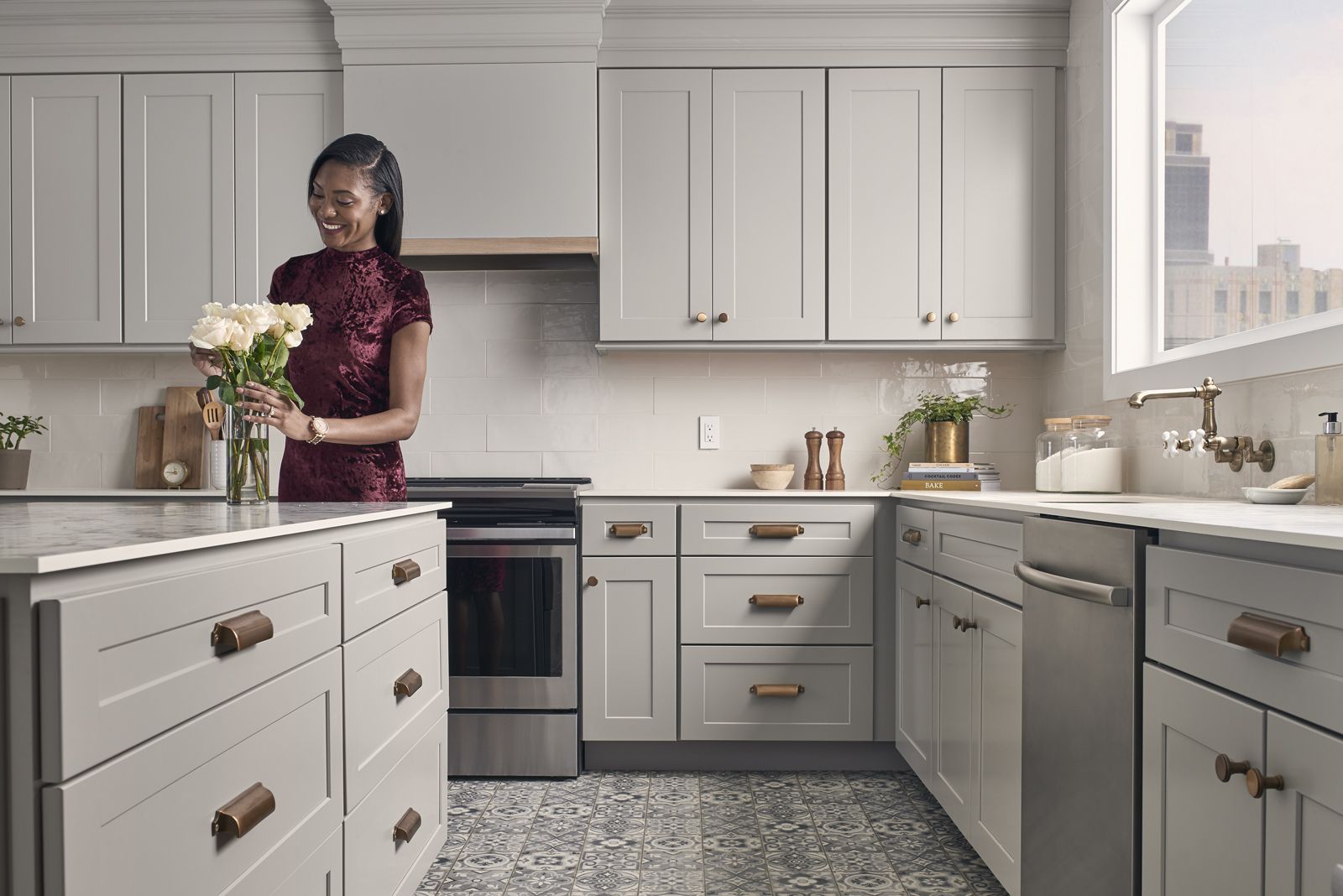 Woman arranging flowers in a modern, light-gray kitchen.