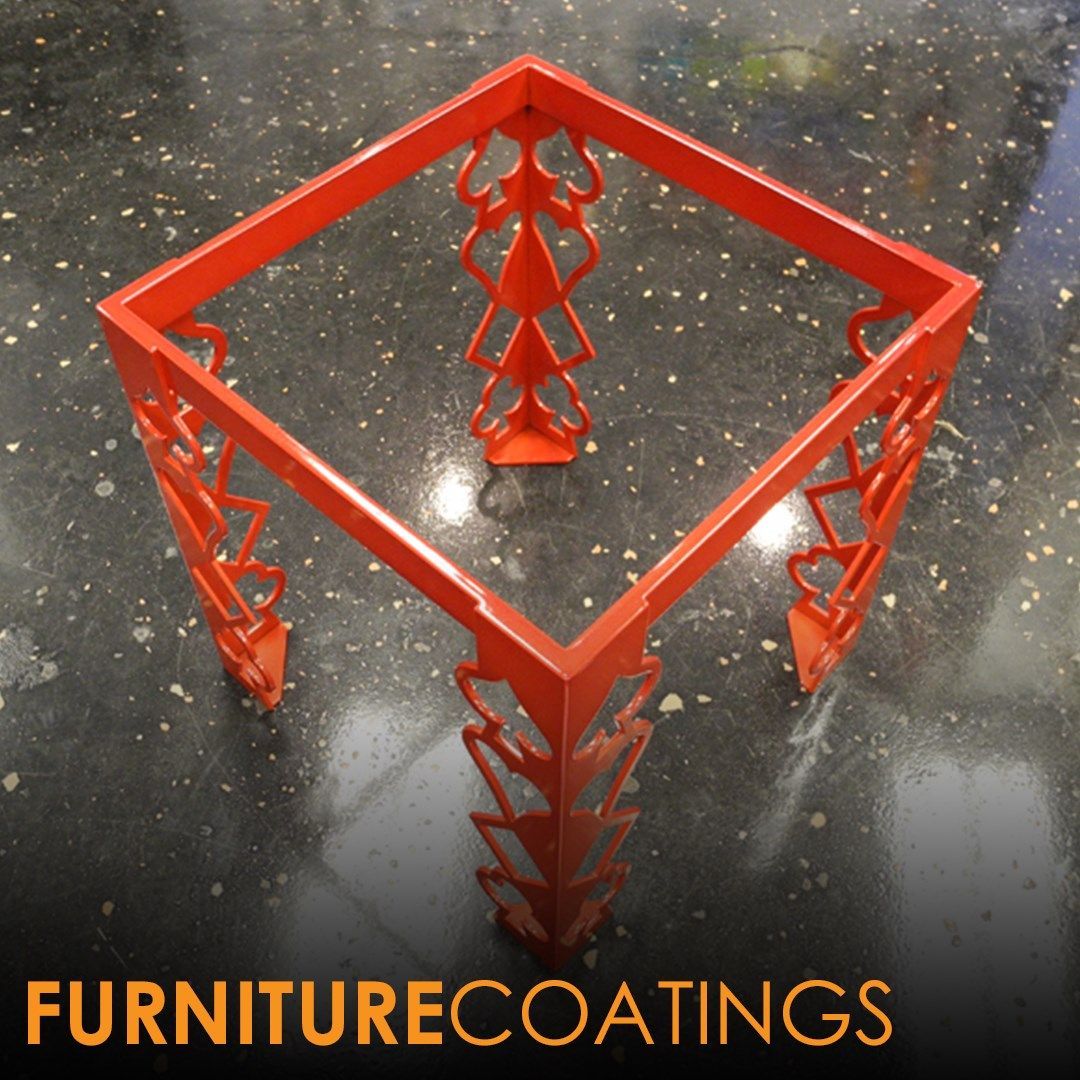 Bright orange metal table base on a speckled surface.