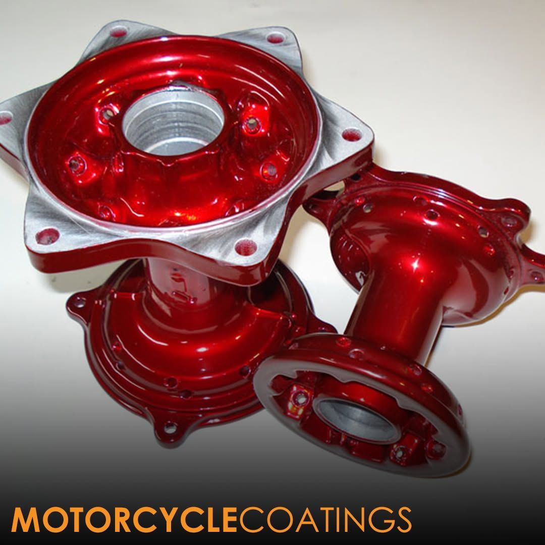 Red powder-coated motorcycle wheel hubs with a logo in the bottom corner reading 