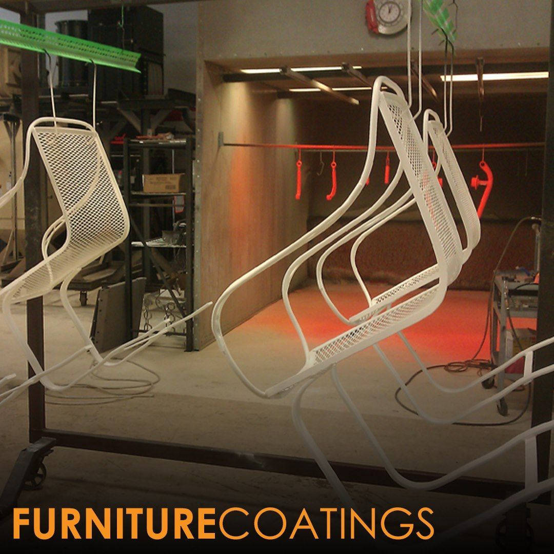 White chairs hanging in an industrial paint booth for coating.