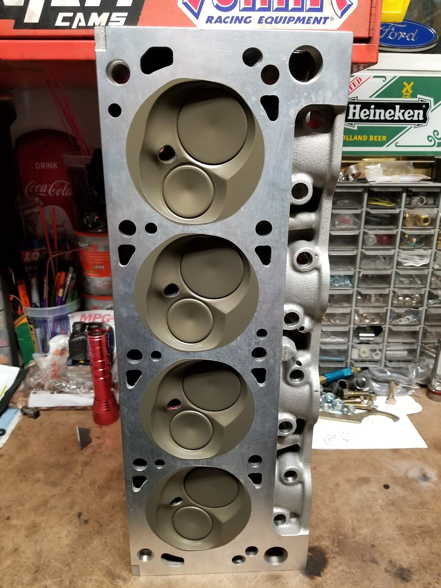Aluminum engine cylinder head with visible valve chambers.