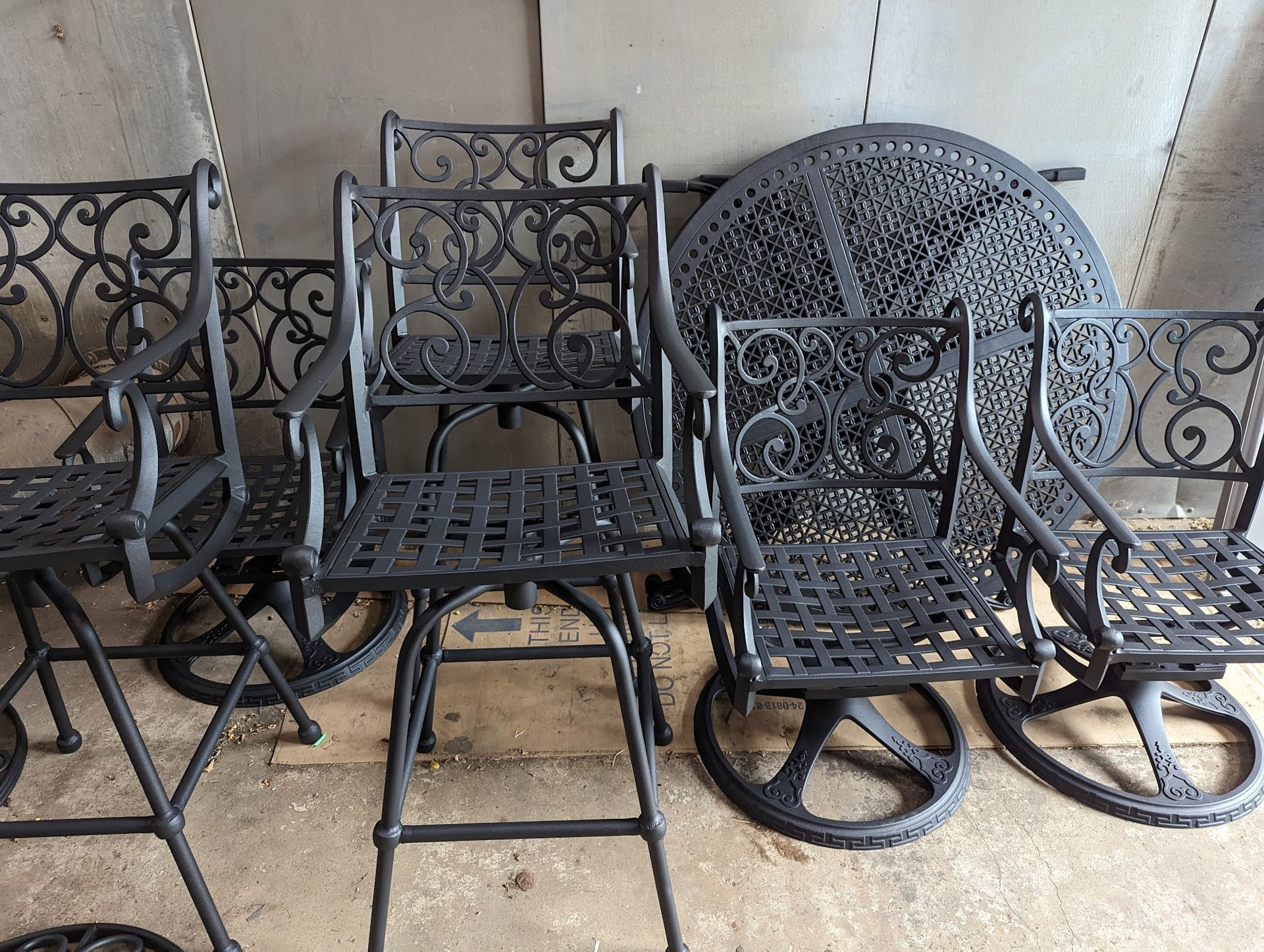 Black metal patio furniture set: chairs and round table.