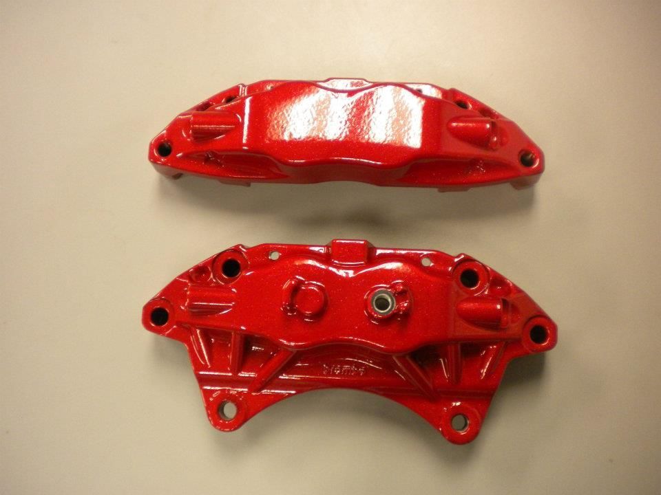Two red automotive brake calipers.