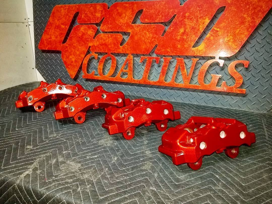 Red brake calipers in front of an orange 