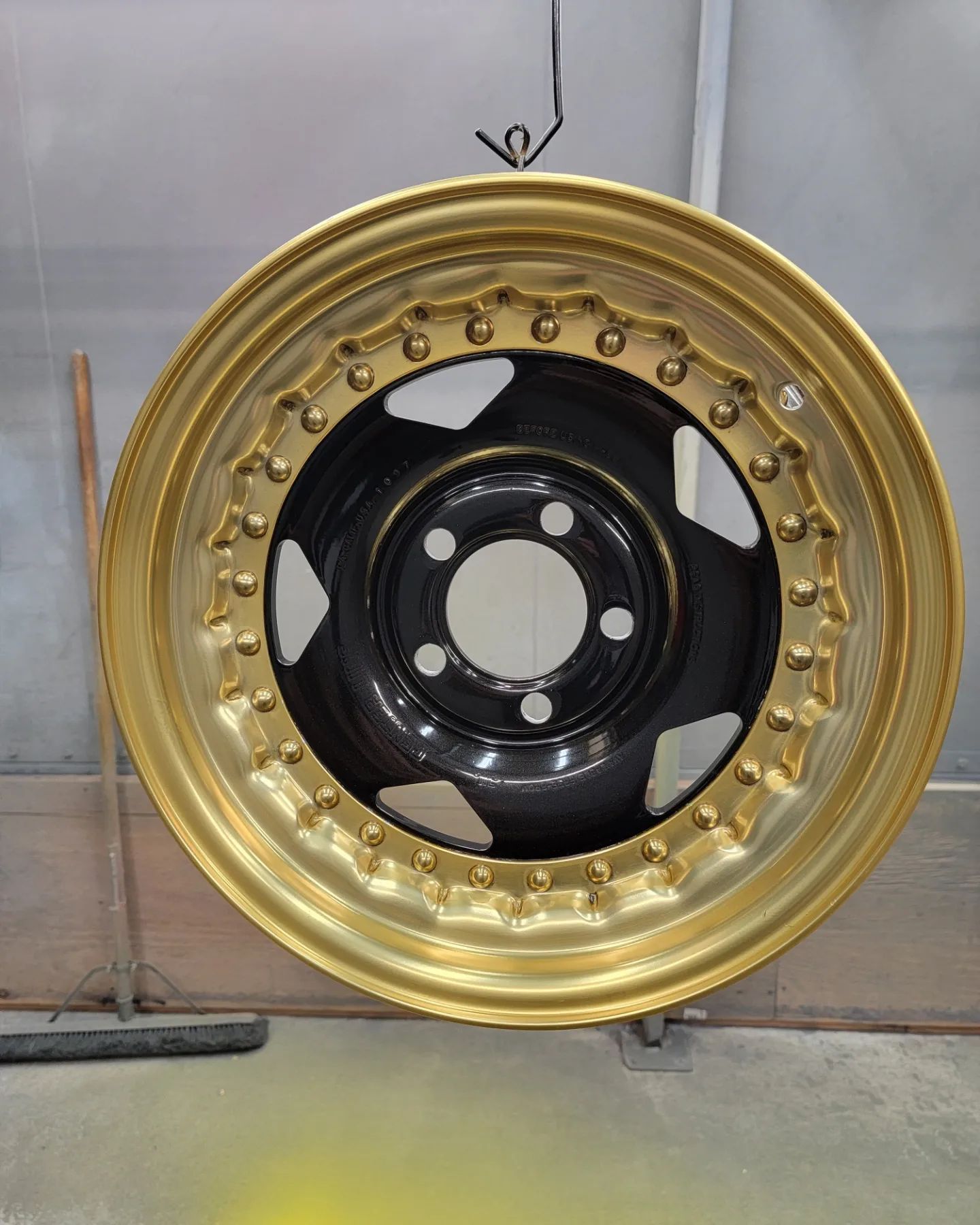 Gold rimmed car wheel with a black center.