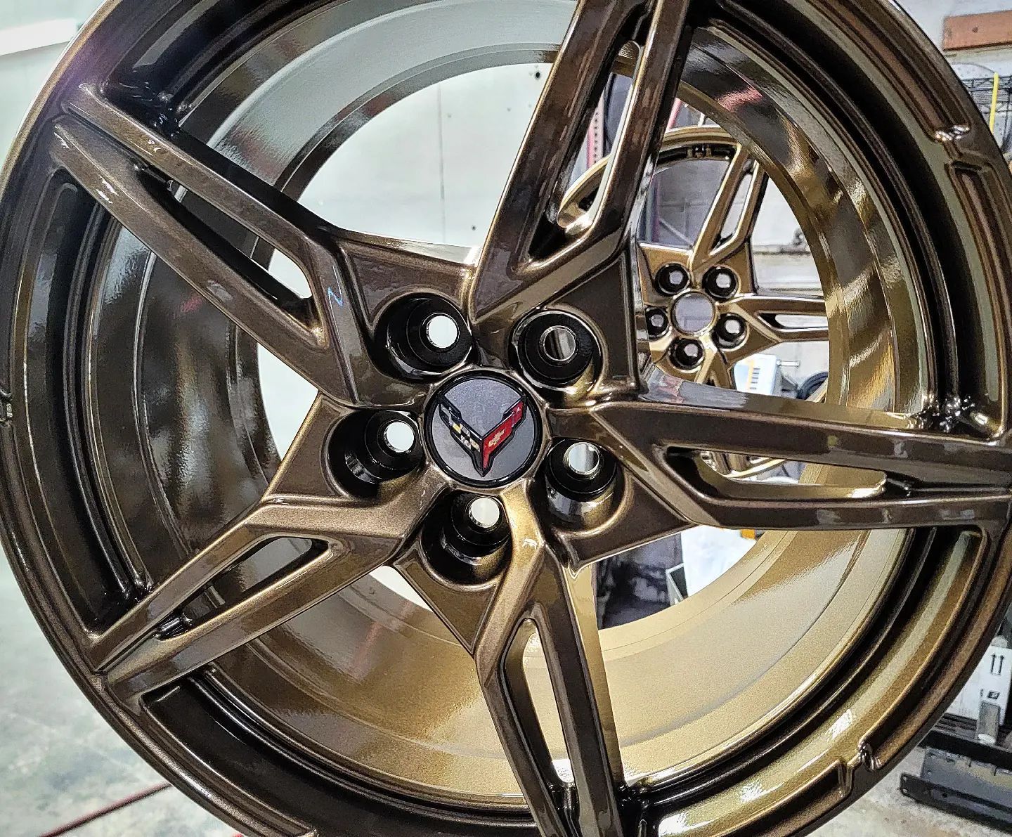 Gold-toned Corvette wheel with a black center cap featuring the Corvette emblem.