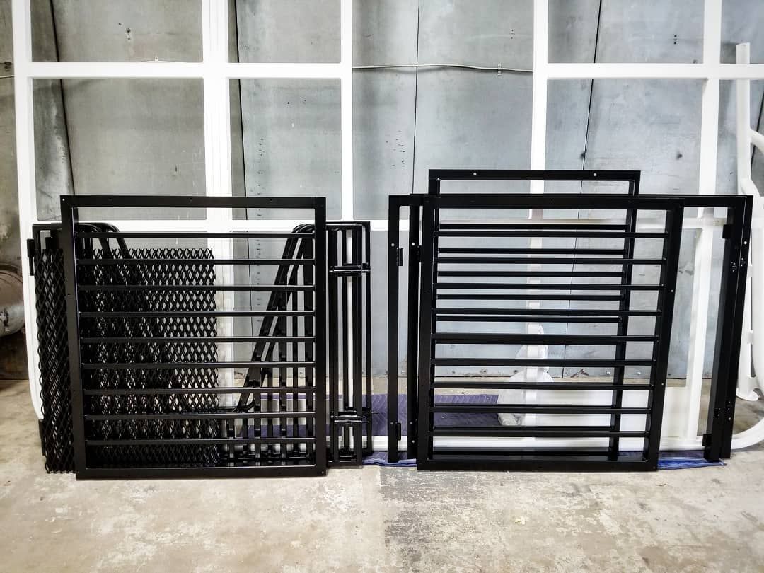 Black metal window frames and bars. Some are stacked, others upright, against white-framed windows.