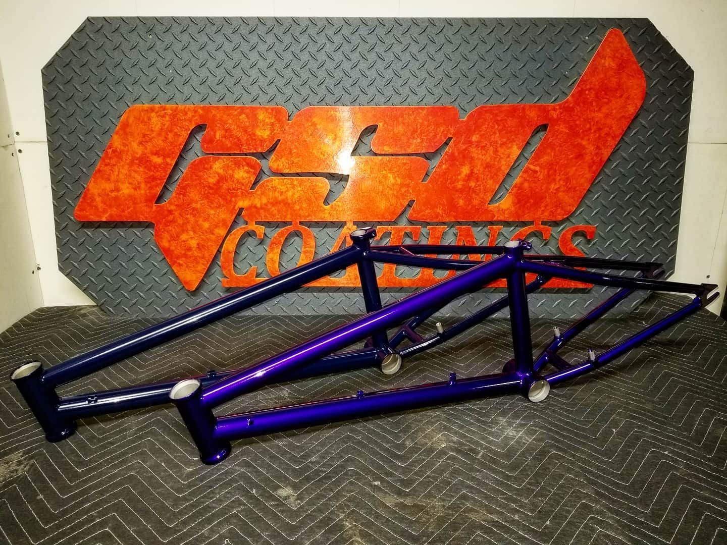 Red painted car frame in a paint booth.