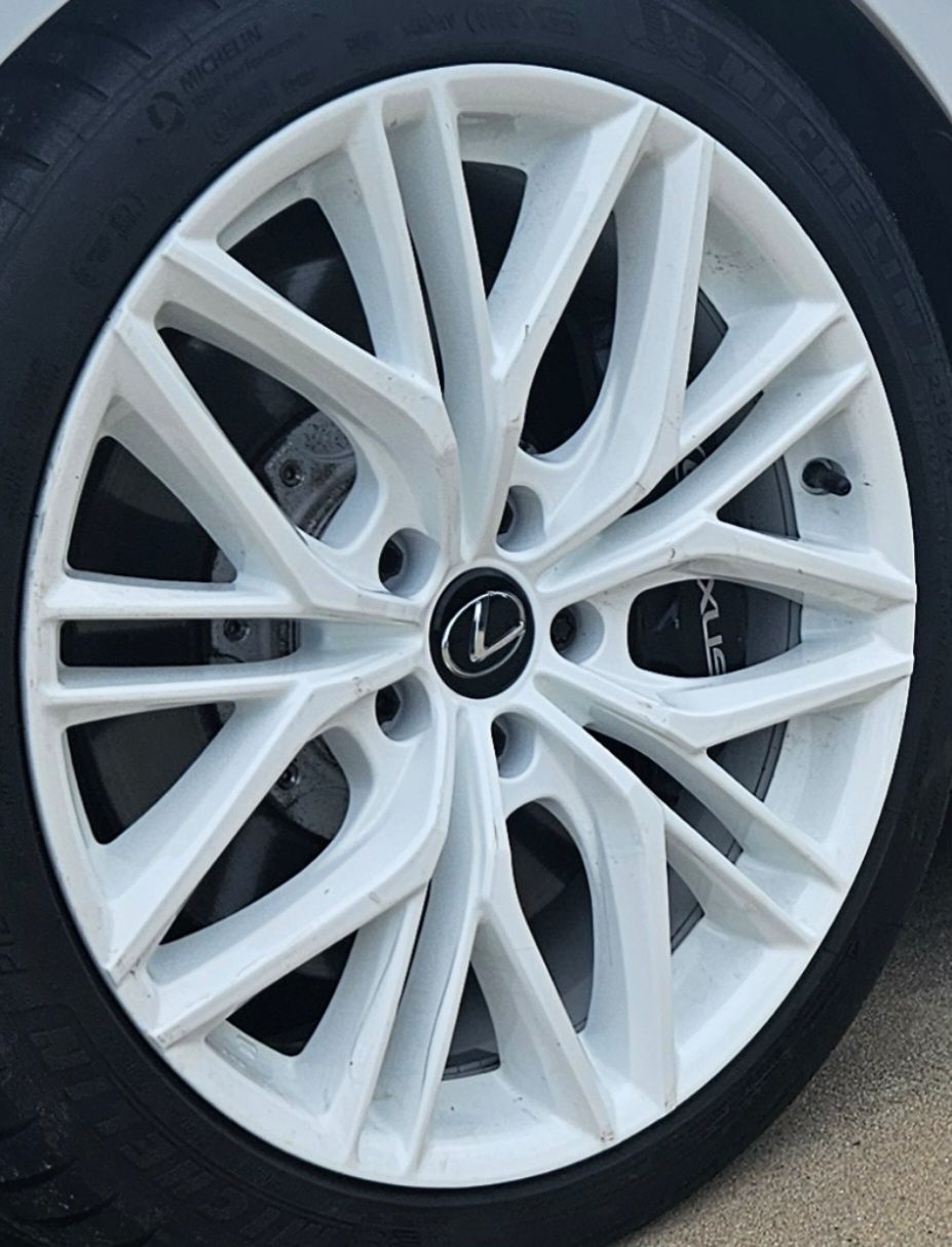 White Lexus car wheel with black tire.