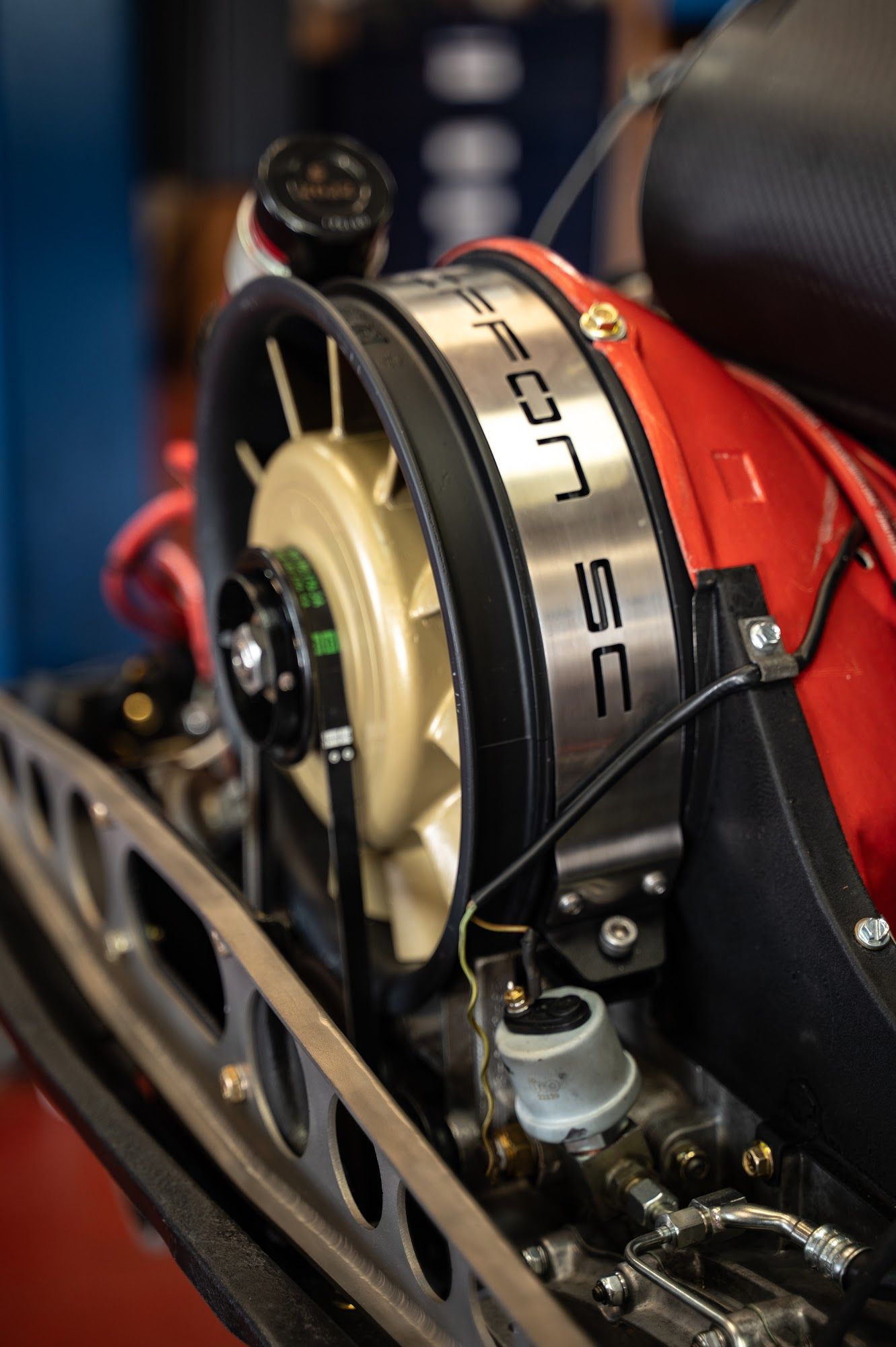 Close-up of a red Porsche engine with a gold fan and silver 