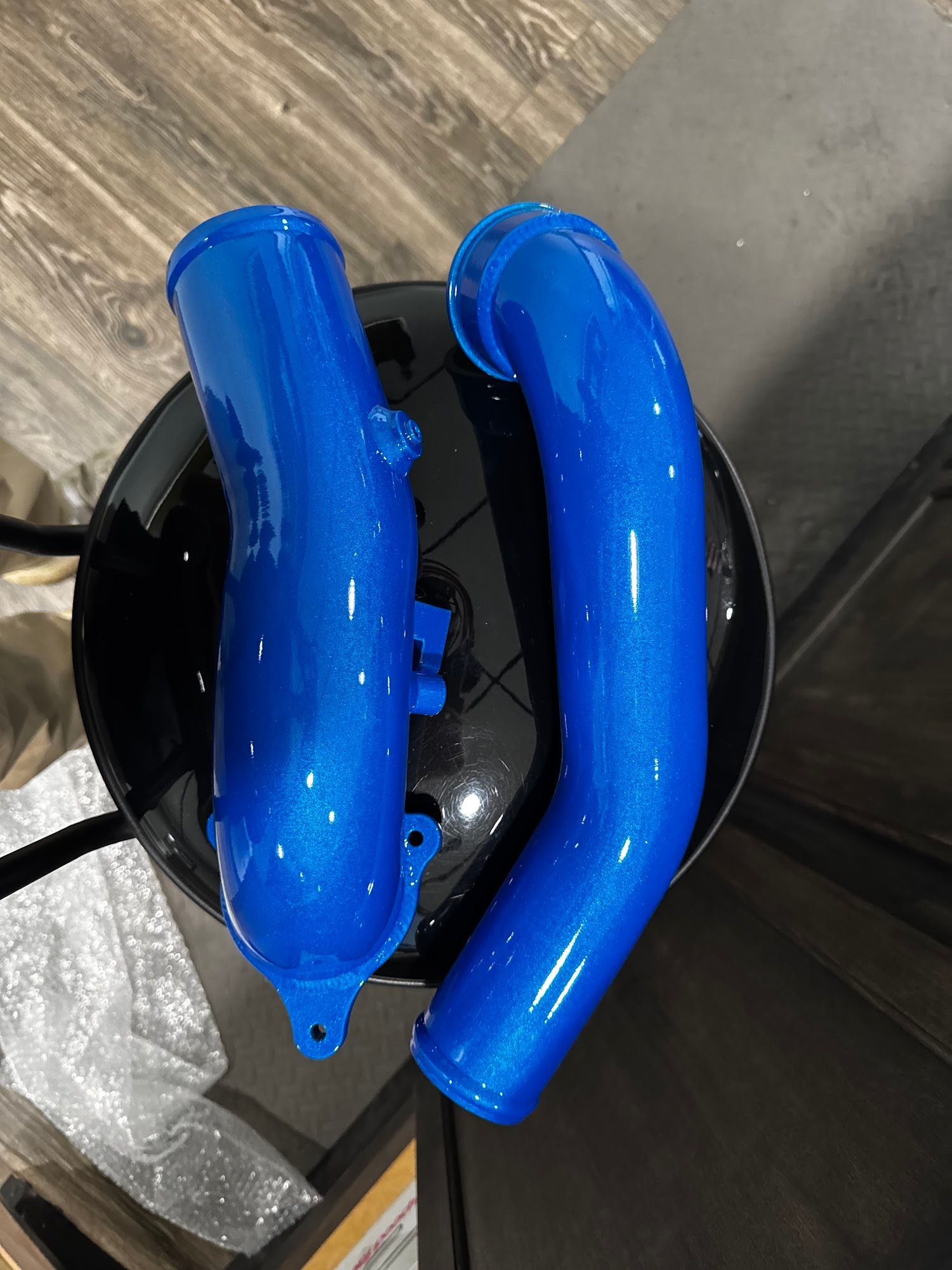 Two blue, glittery metal tubes on a black surface.