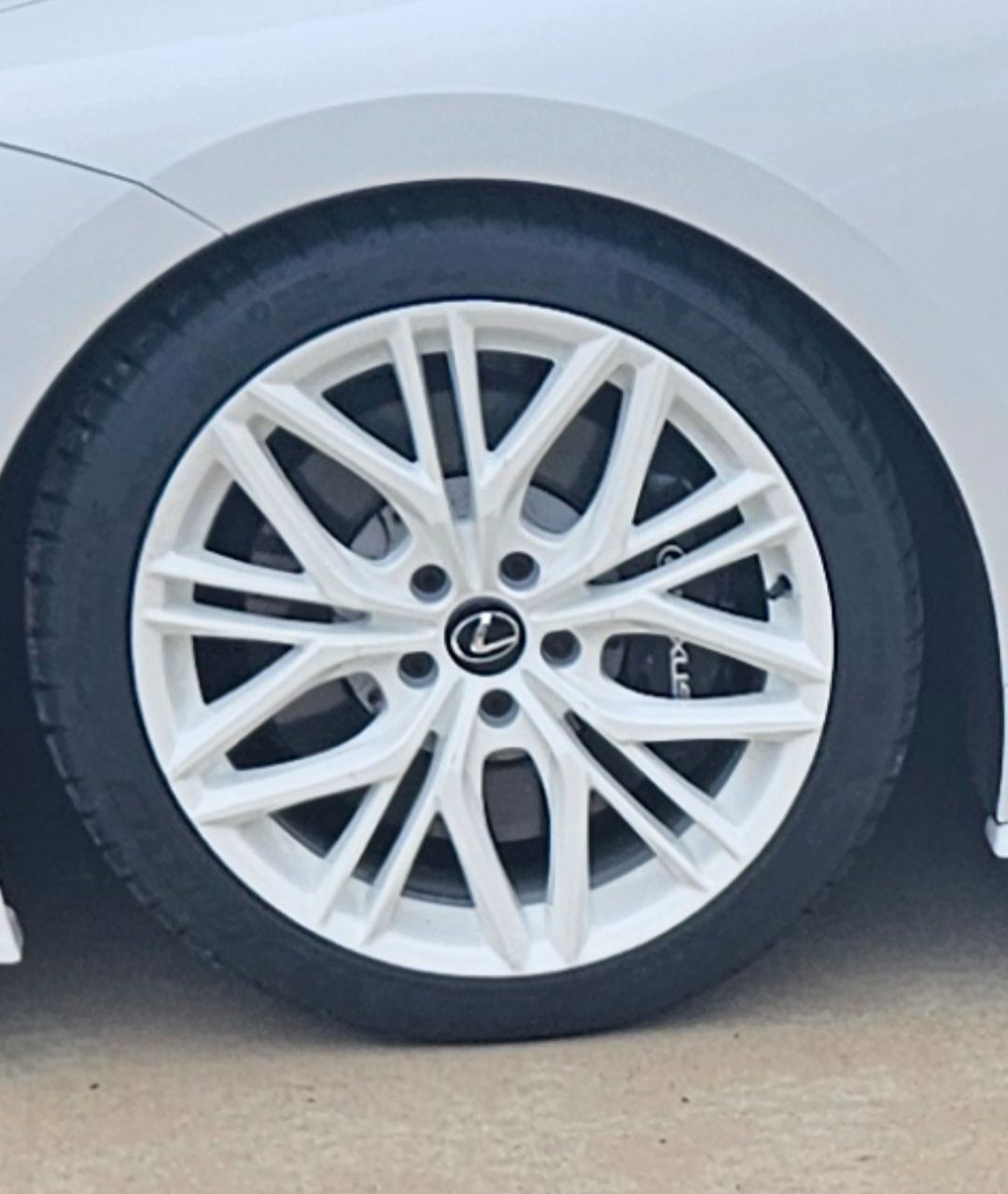 White Lexus car wheel. White rim with black tire.
