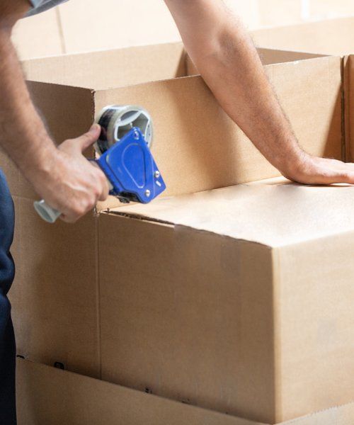 Professional Worker Closing a Box Using Tape