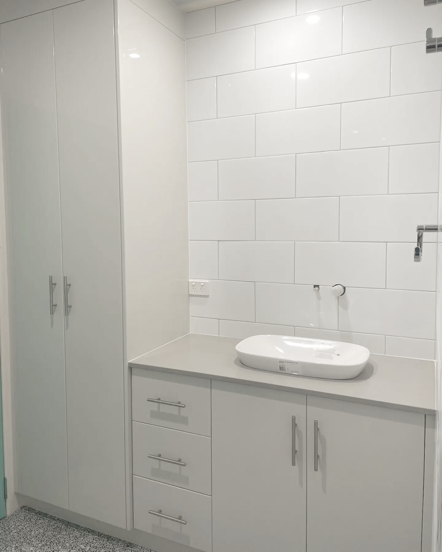 Bathroom with a white sink, cabinets, and tiled wall — Crispin Cabinetmakers in Grafton, NSW