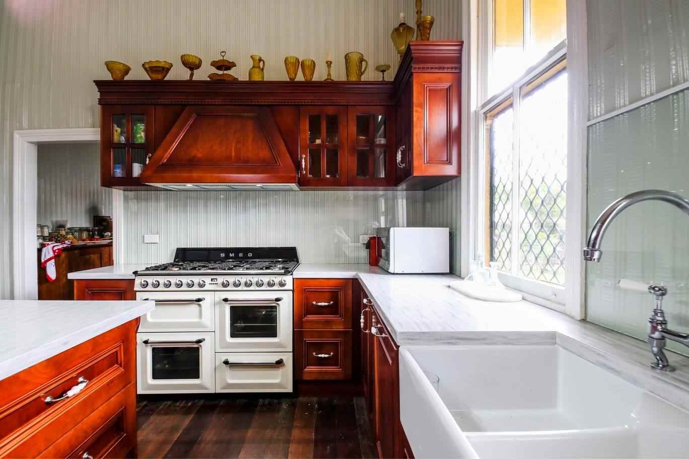 A Kitchen With a Stove and a Sink and a Window — Crispin Cabinetmakers in Yamba, NSW