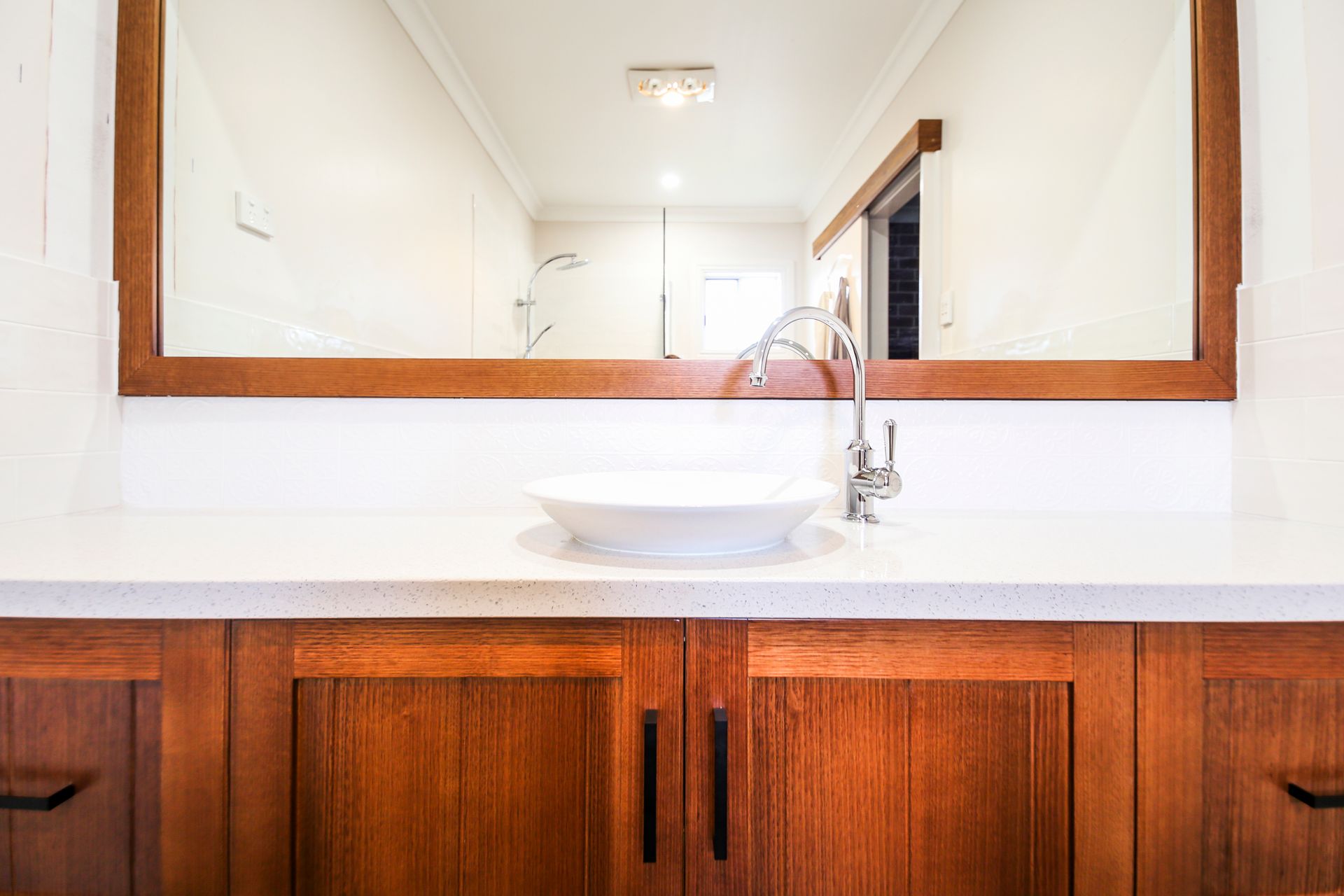 A Bathroom With a Sink, Mirror and Oak cabinets — Crispin Cabinetmakers in Woolgoolga, NSW
