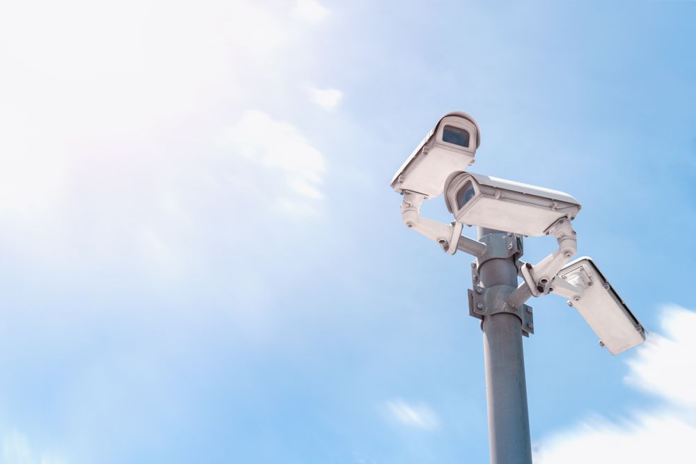 Three Security Cameras Are Sitting on Top of a Pole Against a Blue Sky — Darwin Lock & Key In Humpty Doo, NT