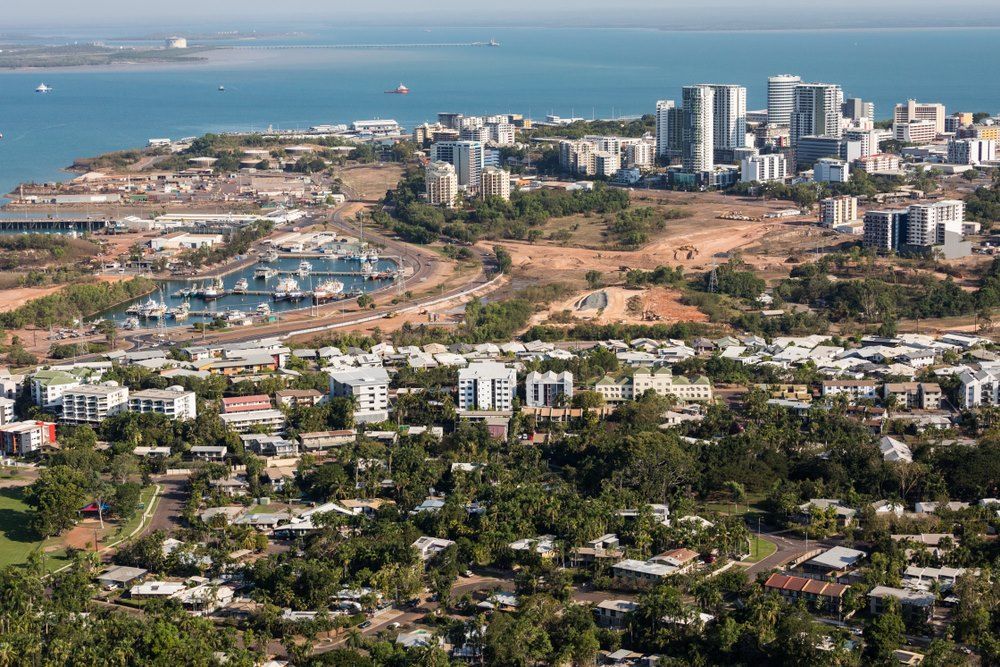 An Aerial View of a City Surrounded by Trees and Buildings Next to the Ocean — Darwin Lock & Key In Coconut Grove, NT