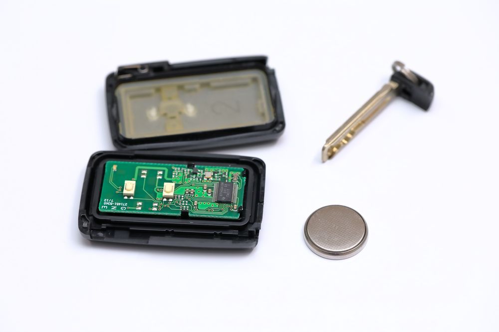 The Inside of a Car Key Fob With a Battery and a Key — Darwin Lock & Key In Coconut Grove, NT