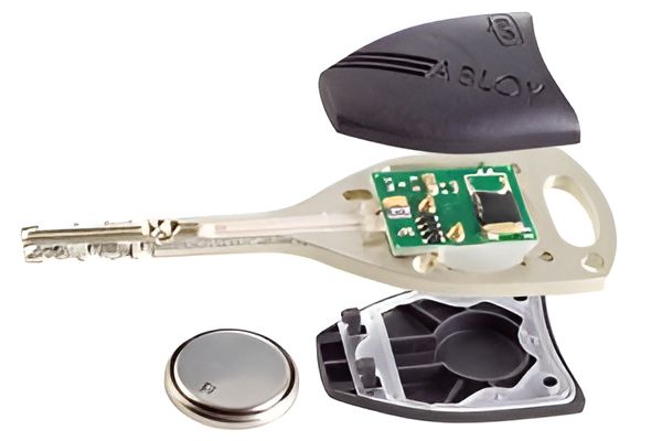 The Inside of a Key is Shown With a Battery Next to It — Darwin Lock & Key In Coconut Grove, NT