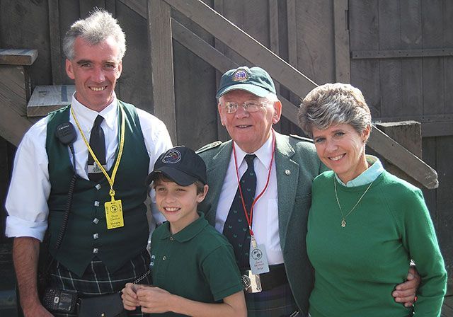 A group of people posing for a picture including a boy wearing a kilt