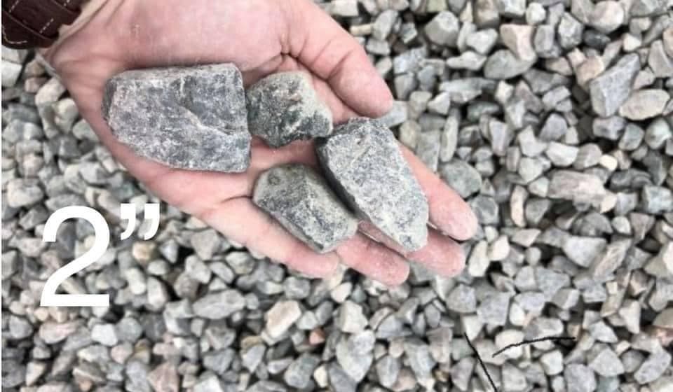 A person is holding a pile of gravel in their hand.