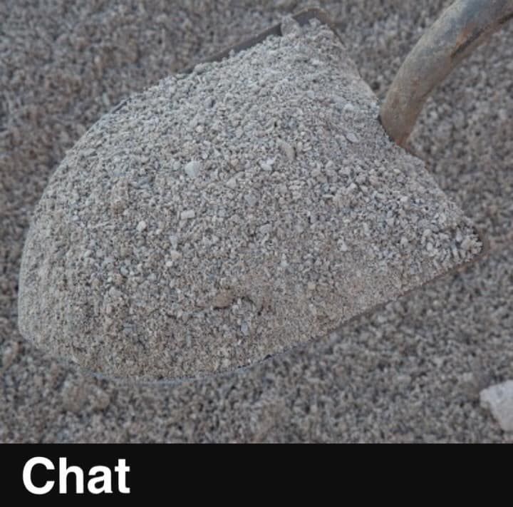 A shovel is scooping up a pile of chat