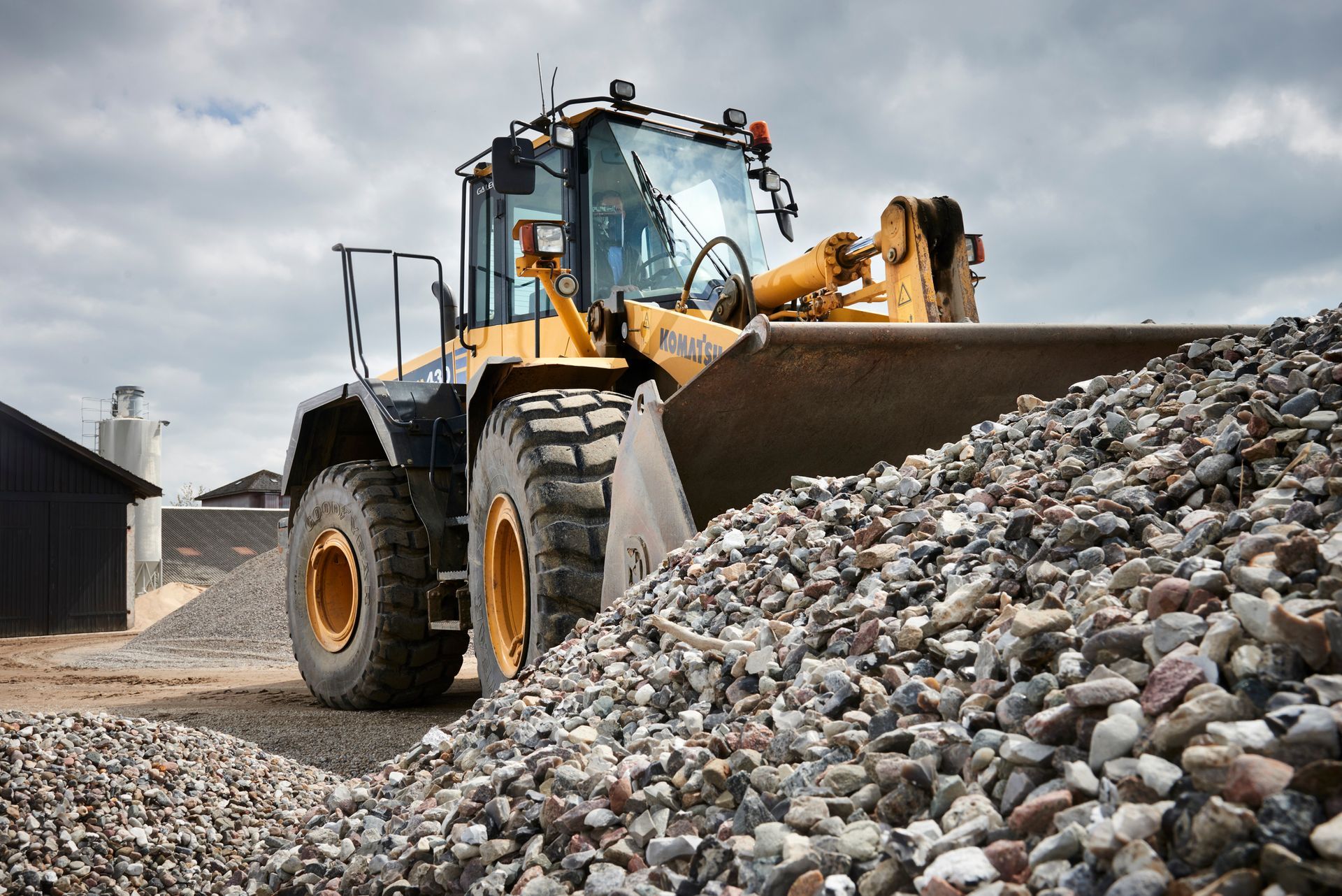 Heavy excavator loading sand in gravel pit for projects from trusted gravel supplier.