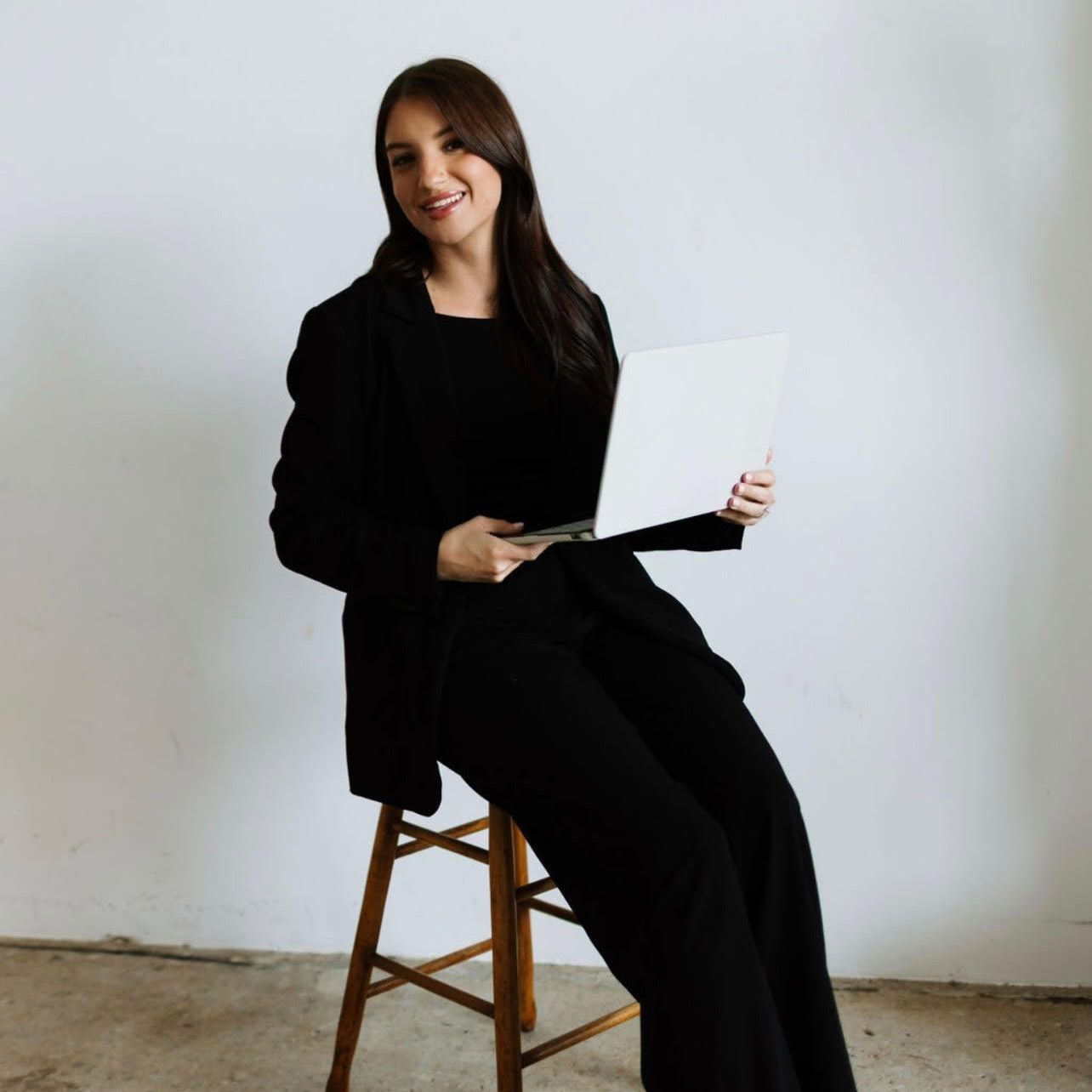 A woman is wearing a gray sweater and a black shirt.