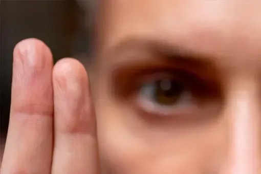 A close up of a person 's finger and eye.