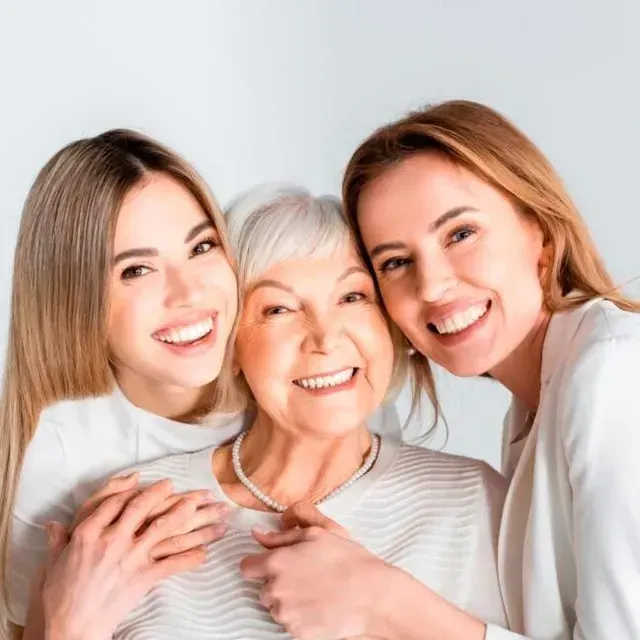 Three women are posing for a picture together and smiling.