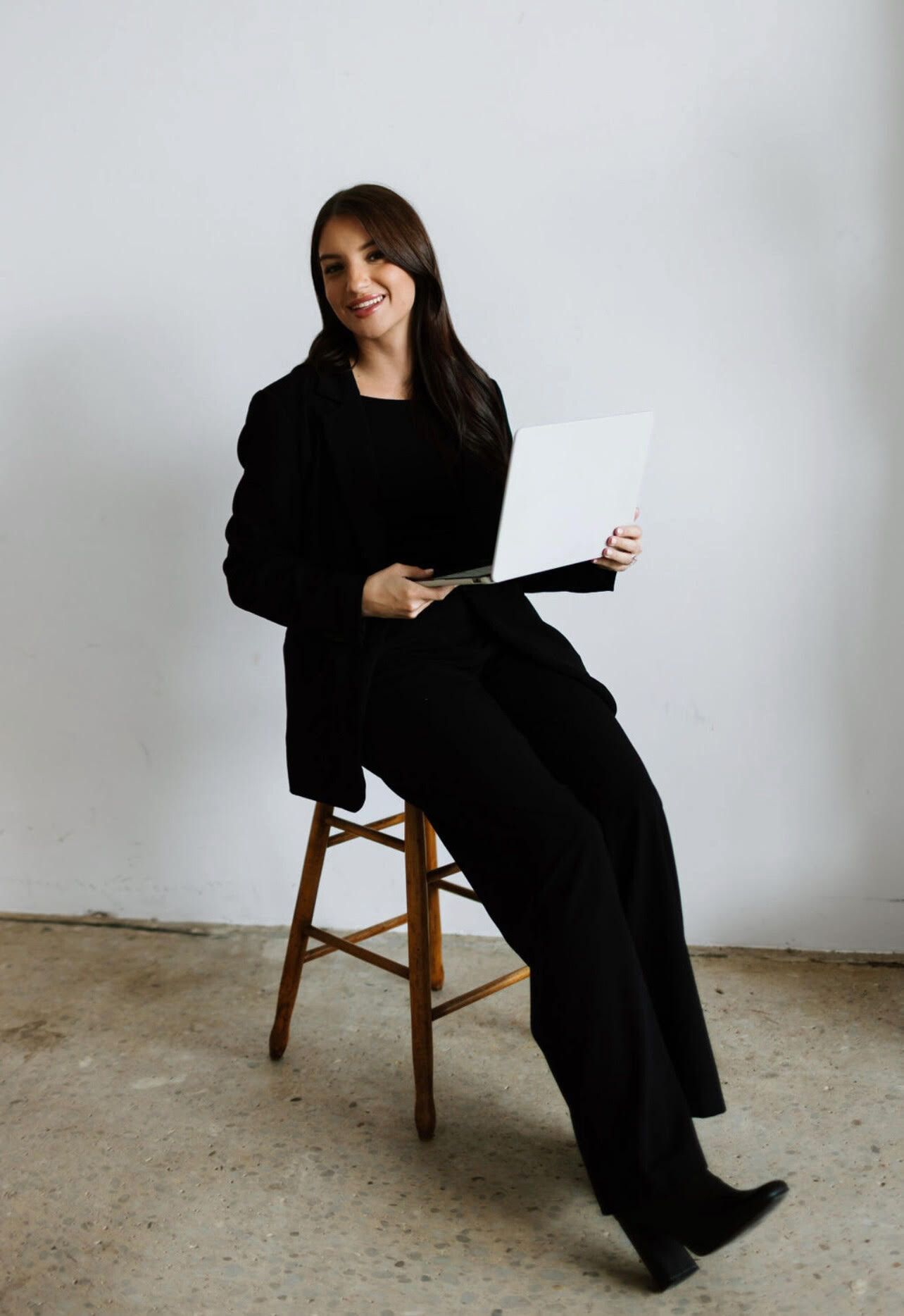 A woman is wearing a gray sweater and a black shirt.