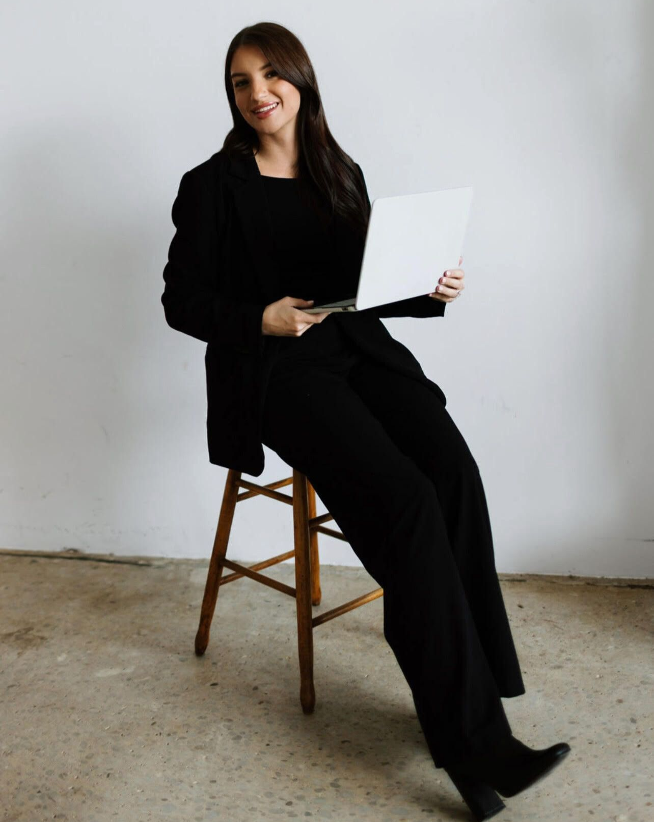 A woman is wearing a gray sweater and a black shirt.