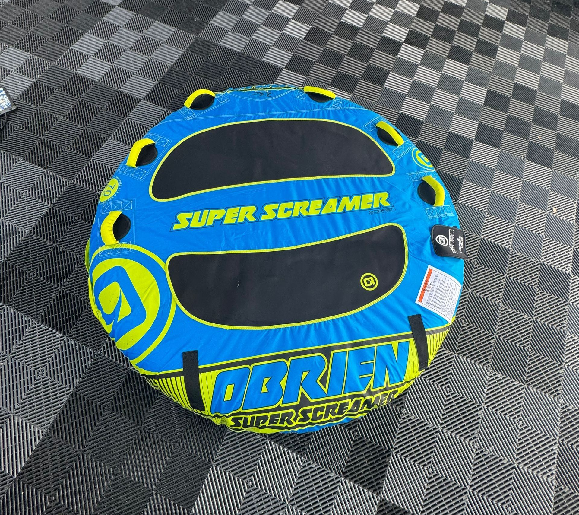 A pontoon boat is docked on the shore of a lake.