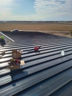A man is working on the roof of a building.